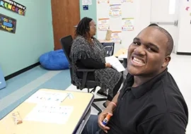 Student Smiling while sitting at Smartboard